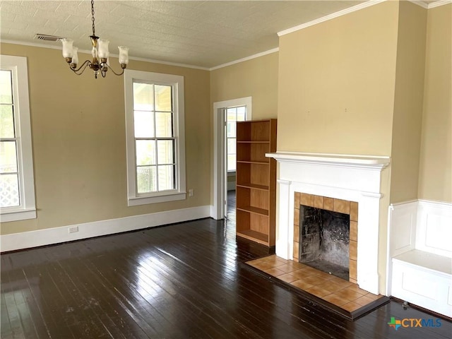 114 N Market St, Goliad, TX 77963 - unfurnished living room featuring a chandelier, hardwood / wood-style floors, ornamental molding, and a tile fireplace