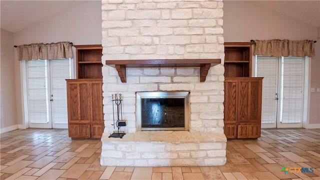 unfurnished living room with baseboards, vaulted ceiling, and a stone fireplace