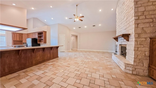 kitchen featuring open shelves, freestanding refrigerator, open floor plan, a kitchen breakfast bar, and a ceiling fan