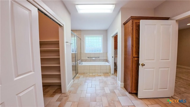 bathroom with a garden tub, toilet, and a shower stall