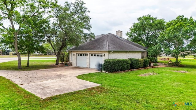 view of home's exterior featuring a garage, a yard, driveway, and a chimney