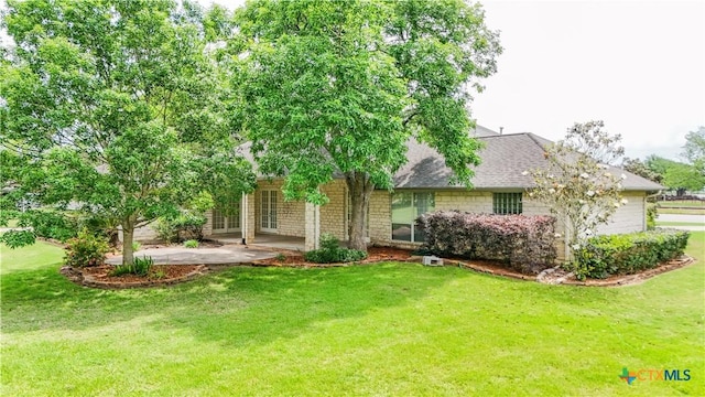 rear view of property featuring a lawn, a patio, and roof with shingles