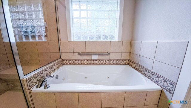 bathroom with a whirlpool tub and a stall shower