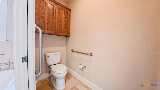 bathroom with baseboards, tile patterned floors, and toilet
