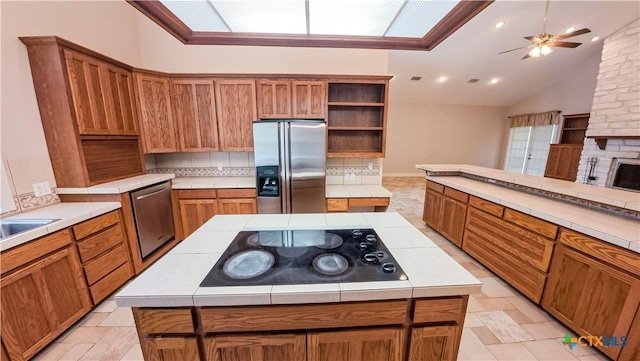kitchen with a center island, open shelves, appliances with stainless steel finishes, and brown cabinets