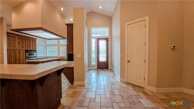 interior space featuring recessed lighting, baseboards, and high vaulted ceiling