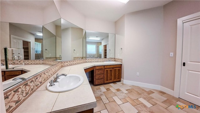 full bathroom with baseboards, a shower with shower door, and vanity