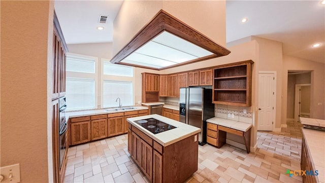 kitchen featuring tile countertops, vaulted ceiling, and a sink