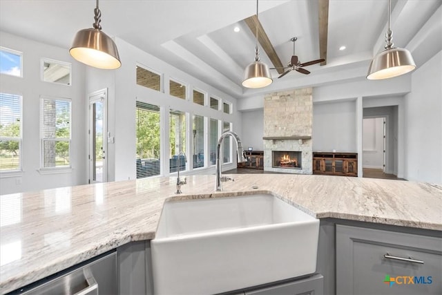 292 Scenic Cyn, New Braunfels, TX 78132 - kitchen featuring gray cabinetry, light stone counters, a stone fireplace, open floor plan, and beamed ceiling
