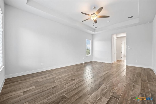 292 Scenic Cyn, New Braunfels, TX 78132 - unfurnished room with a raised ceiling, a ceiling fan, and dark wood-type flooring