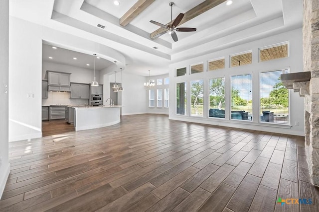 292 Scenic Cyn, New Braunfels, TX 78132 - unfurnished living room with a raised ceiling, ceiling fan, dark wood-style flooring, recessed lighting, and a high ceiling