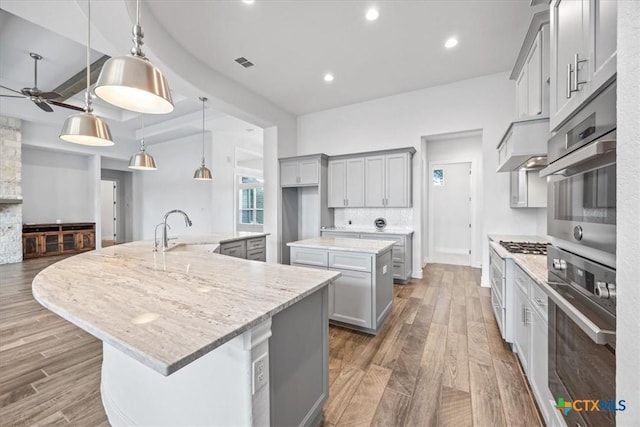 292 Scenic Cyn, New Braunfels, TX 78132 - kitchen with a spacious island, gray cabinetry, extractor fan, ceiling fan, and wood finished floors