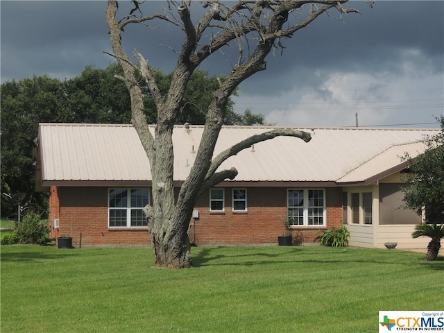 1608 S Virginia St, Port Lavaca, TX 77979 - view of front of home featuring a front yard, brick siding, and a metal roof