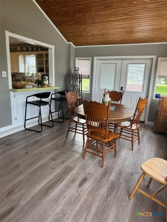 1608 S Virginia St, Port Lavaca, TX 77979 - dining area featuring vaulted ceiling, wooden ceiling, wood finished floors, and crown molding