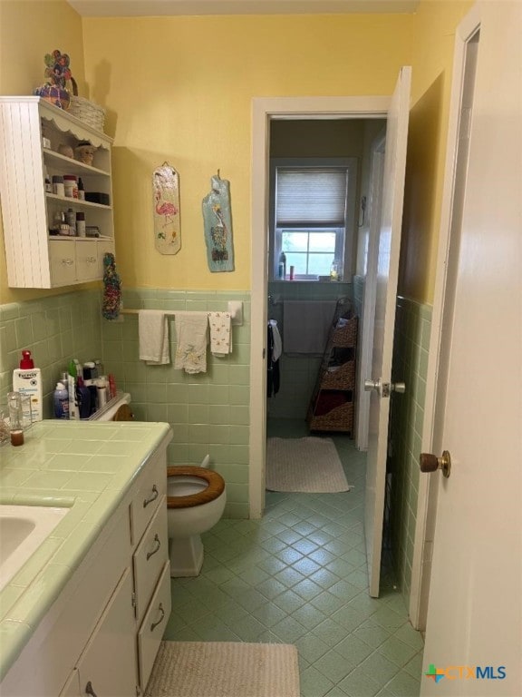 1608 S Virginia St, Port Lavaca, TX 77979 - bathroom with tile walls, tile patterned flooring, wainscoting, and vanity