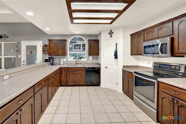 kitchen featuring appliances with stainless steel finishes, kitchen peninsula, sink, and light tile patterned floors