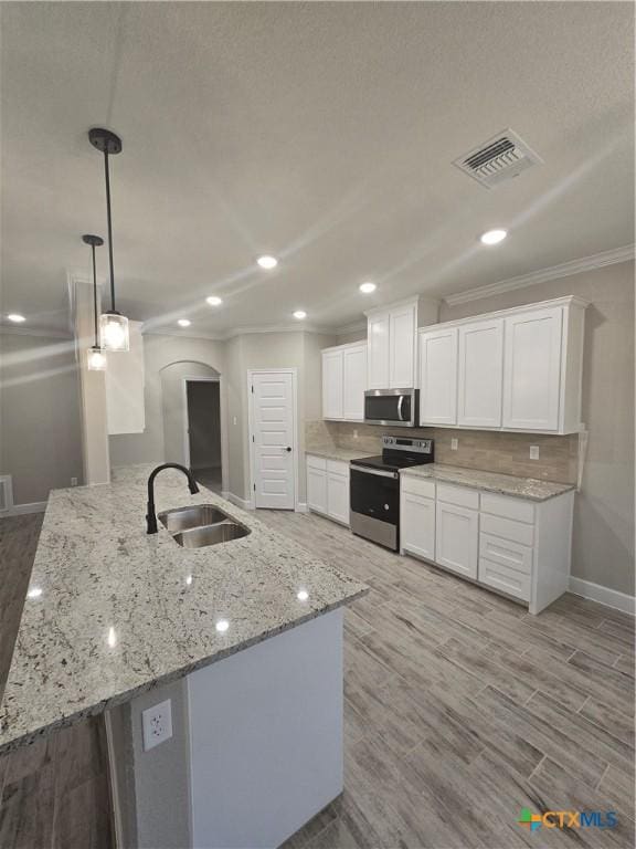 kitchen with visible vents, appliances with stainless steel finishes, hanging light fixtures, white cabinetry, and a sink