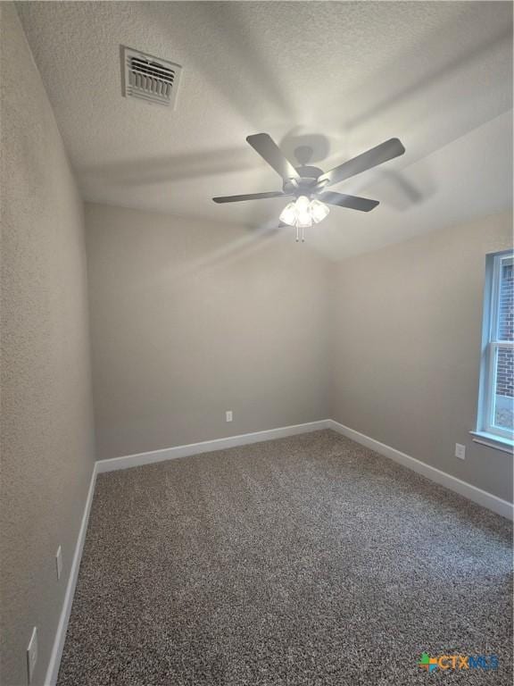 unfurnished room with carpet, visible vents, a textured ceiling, and baseboards