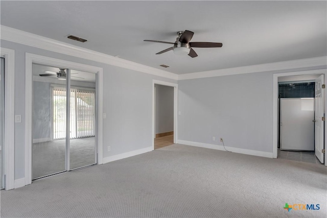 spare room with light carpet, ceiling fan, and ornamental molding