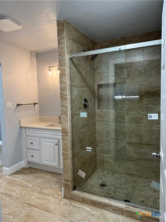 bathroom with vanity and a shower with door