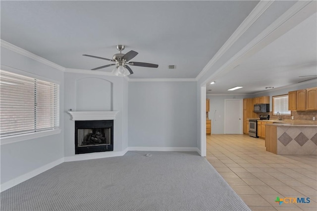 unfurnished living room featuring crown molding, sink, light tile patterned floors, and ceiling fan