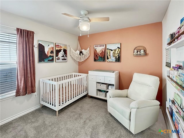 bedroom with a nursery area, ceiling fan, and light carpet