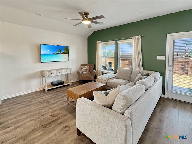 living room featuring wood-type flooring, vaulted ceiling, a wealth of natural light, and ceiling fan