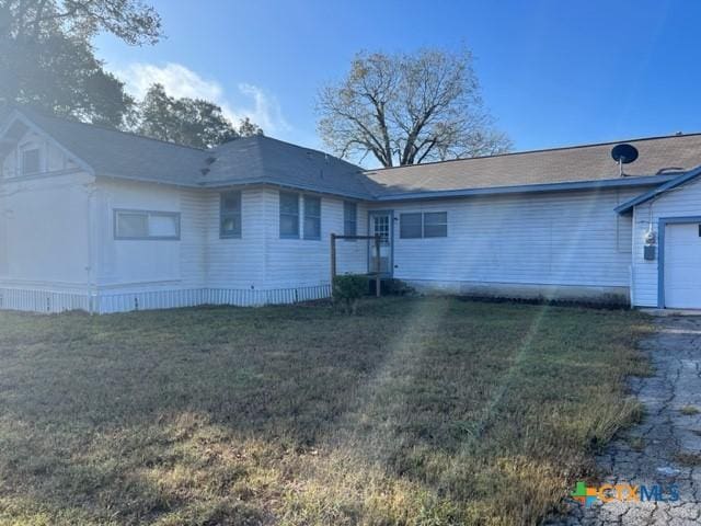 back of property with a yard and a garage