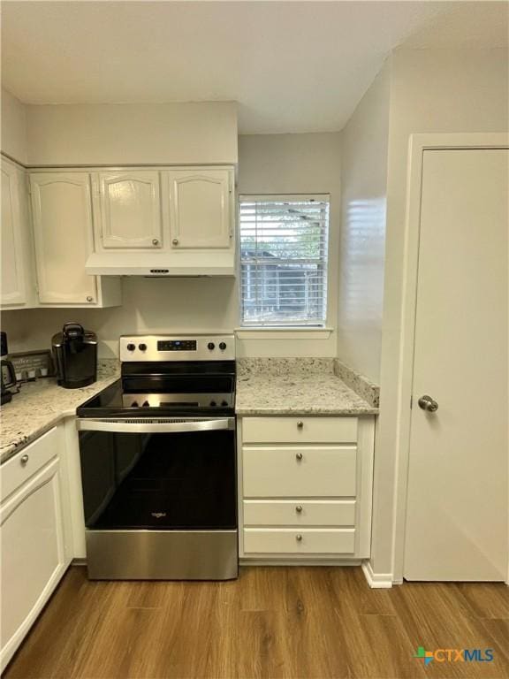 kitchen with white cabinetry, stainless steel electric range oven, and light hardwood / wood-style flooring