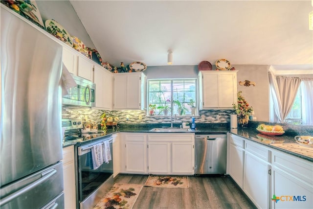 4108 Red River Cir, Temple, TX 76504 - kitchen with appliances with stainless steel finishes, plenty of natural light, decorative backsplash, wood finished floors, and vaulted ceiling