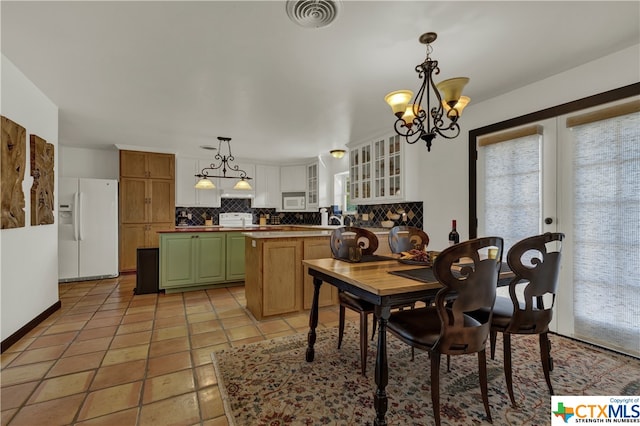 dining space with light tile patterned floors and an inviting chandelier