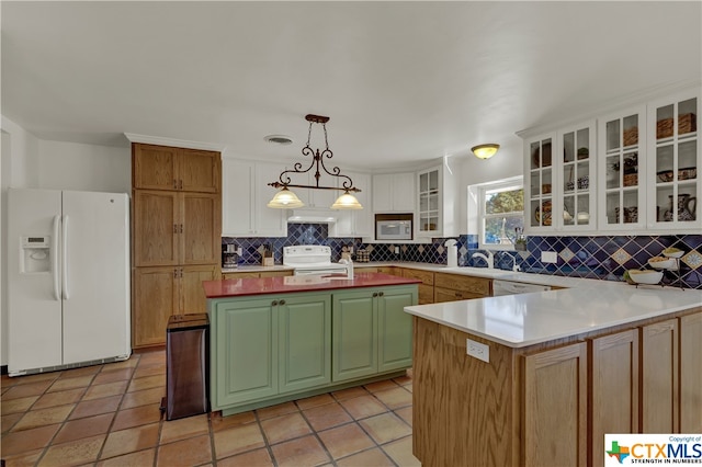 kitchen featuring a kitchen island, backsplash, pendant lighting, white cabinets, and white appliances