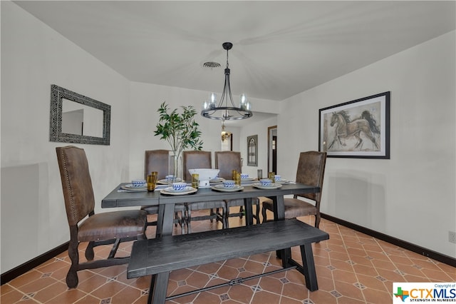 tiled dining room with an inviting chandelier