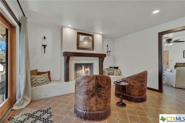 living area featuring ceiling fan and tile patterned flooring