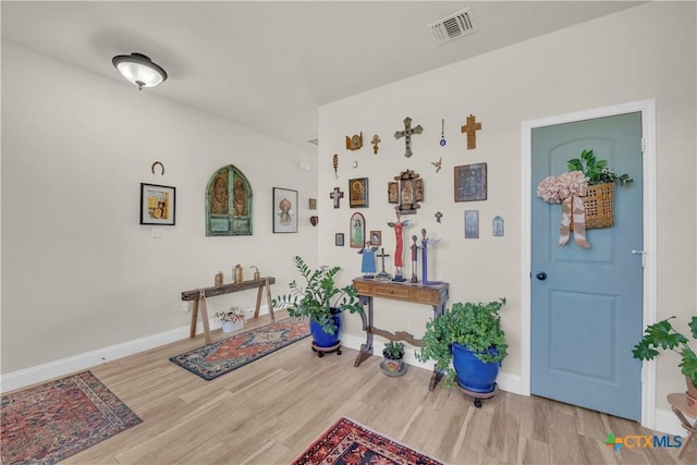 entryway featuring wood finished floors, visible vents, and baseboards