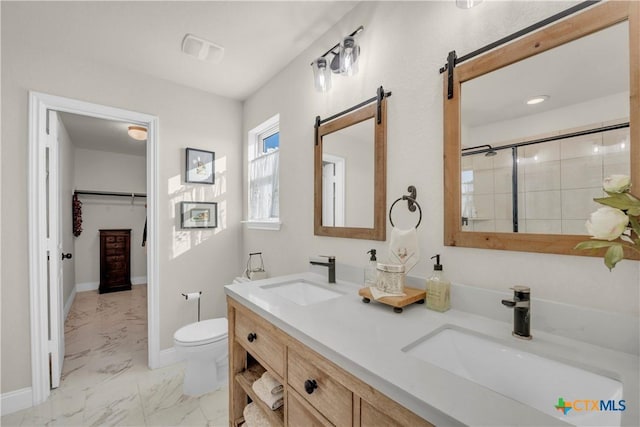 bathroom featuring a sink, toilet, marble finish floor, and a tile shower