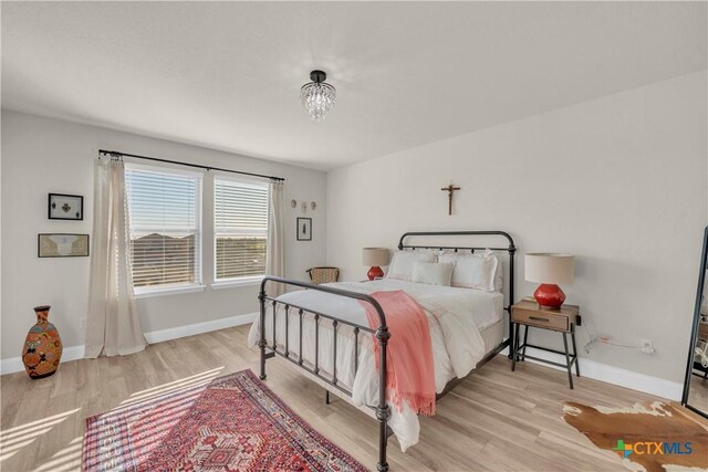 bedroom with baseboards and light wood-type flooring