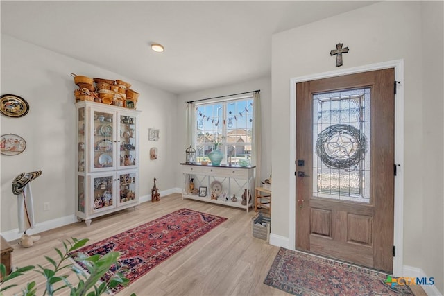 foyer with wood finished floors and baseboards