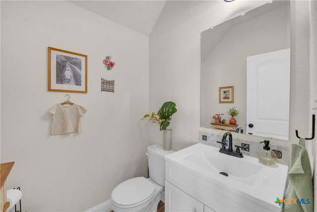 bathroom with vanity, vaulted ceiling, and toilet