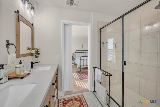 bathroom with visible vents, connected bathroom, double vanity, a stall shower, and a sink