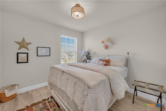 bedroom featuring wood finished floors and baseboards