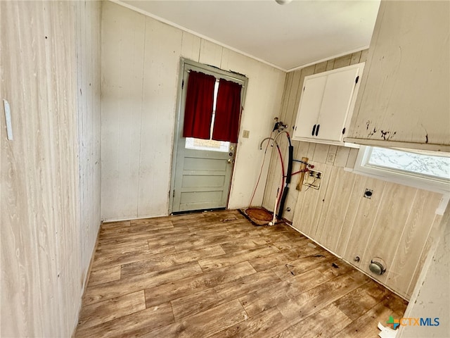 washroom featuring light wood-type flooring, washer hookup, and wood walls