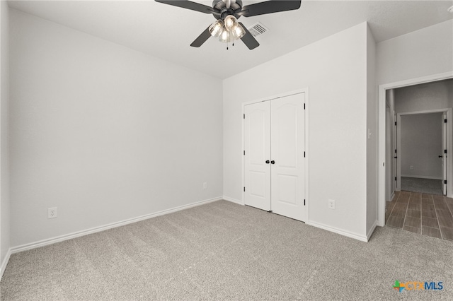 unfurnished bedroom featuring carpet floors, ceiling fan, and a closet