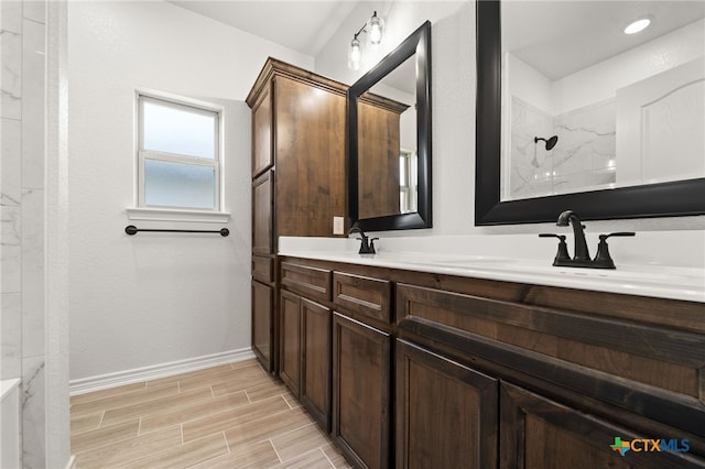 bathroom with tiled shower and vanity