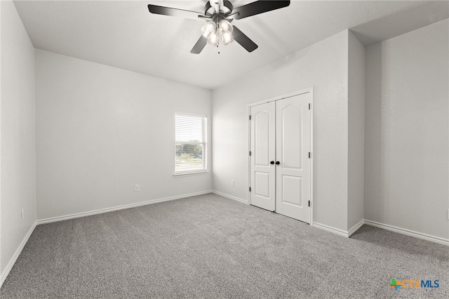 unfurnished bedroom featuring ceiling fan, a closet, and carpet floors