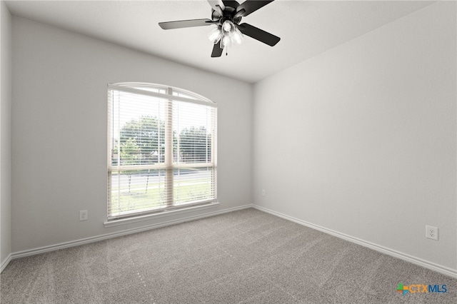 carpeted empty room with a wealth of natural light and ceiling fan