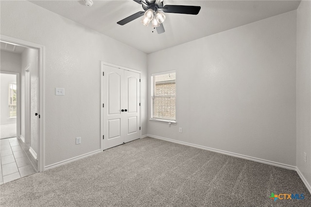 unfurnished bedroom featuring light colored carpet, ceiling fan, and a closet