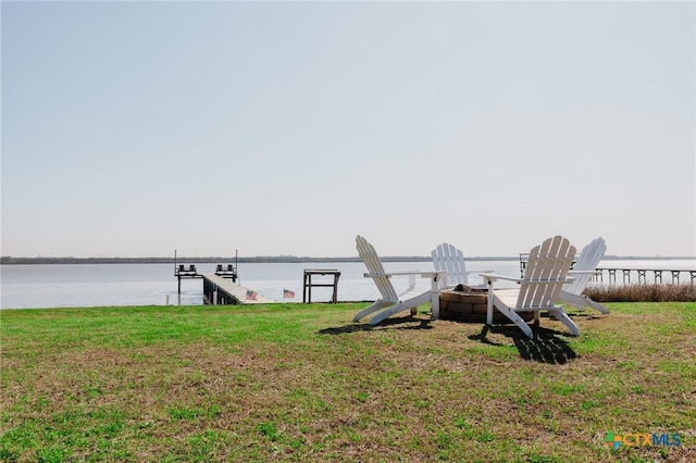 view of dock with a lawn, a water view, and a fire pit