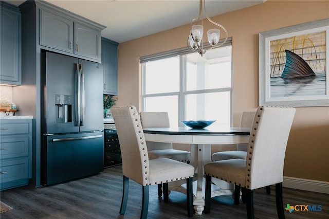 dining room with an inviting chandelier and dark wood-type flooring