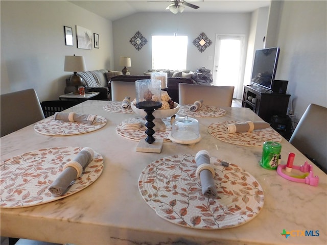 dining space featuring ceiling fan and lofted ceiling